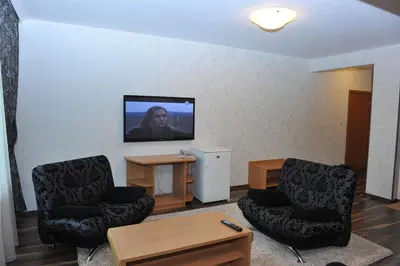 a living room with two chairs and a flat screen tv at Eros Motel in Sandanski