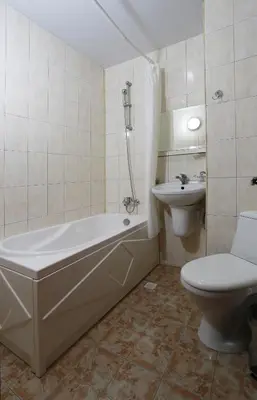 a bathroom with a tub and a toilet and a sink at Acropolis Hotel in Pazardzhik