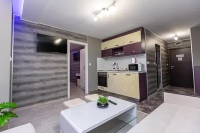 a living room with a white couch and a table at Апартаменти Елеганс in Sandanski
