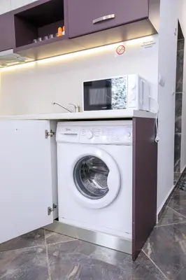 a washing machine in a kitchen with a counter at Апартаменти Елеганс in Sandanski