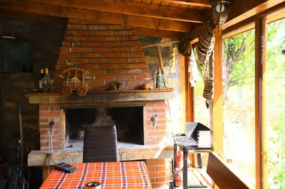 a brick fireplace on a porch of a house at КЪЩА ЗА ГОСТИ “НИЯ” in Smolyan