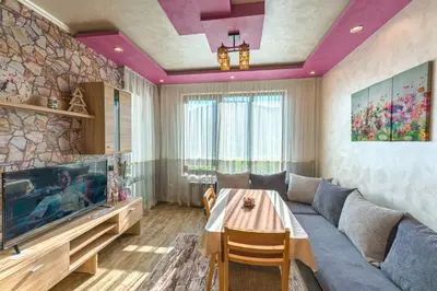 a living room with a couch and a tv at Sweet Home апартамент 530 Смолянски езера in Smolyan