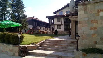 a building with a green umbrella next to some stairs at Sweet Home апартамент 530 Смолянски езера in Smolyan