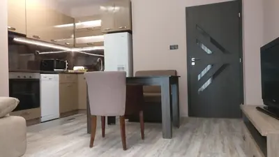 a dining room with a table and a kitchen at Къща за гости Роял in Sandanski