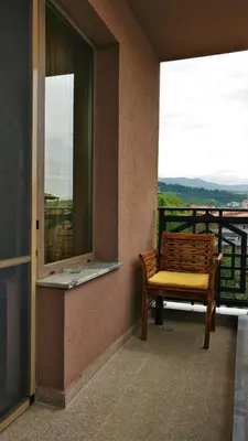a balcony with a bench and a window with a view at Къща за гости Роял in Sandanski