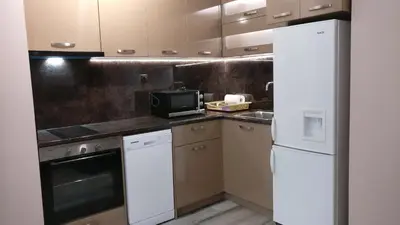 a kitchen with a refrigerator and a microwave at Къща за гости Роял in Sandanski