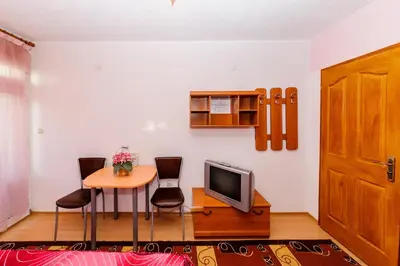 a room with a table and a tv and a table and chairs at Orchideia Studios in Sandanski