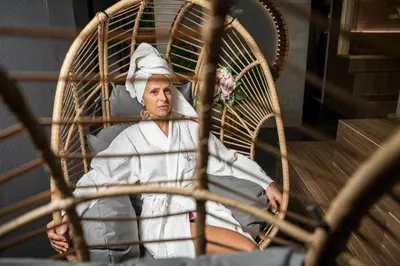 a woman sitting in a chair with a flower at Студио с вана и гледка в 