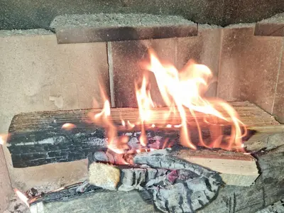 a fire is burning in a brick oven at Къща Томови,стаи за гости in Devin