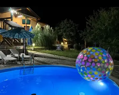 a ball sitting on top of a swimming pool at night at Sunshine villa Dzhigurovo in Sandanski
