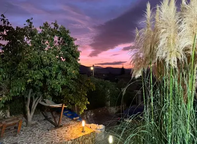 a candle on a table in a garden at dusk at Sunshine villa Dzhigurovo in Sandanski