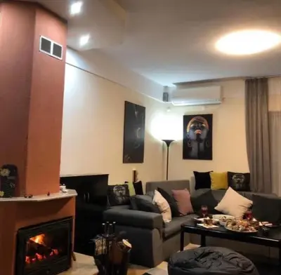 a living room with a couch and a fireplace at Sunshine villa Dzhigurovo in Sandanski