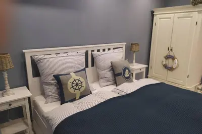 a bedroom with a bed with blue and white pillows at GUESTHOUSE MARIA / КЪЩА ЗА ГОСТИ МАРИЯ / GÄSTEHAUS MARIA in Karlovo
