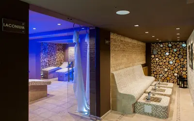 a dressing room with a bench and a bed at Royal Spa Hotel in Velingrad
