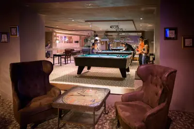 a living room with a pool table and two chairs at Royal Spa Hotel in Velingrad
