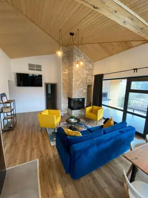 a living room with a blue couch and yellow chairs at Villa Dea & Villa Ina - Villas & SPA Park in Velingrad by Flat Mаnager in Velingrad