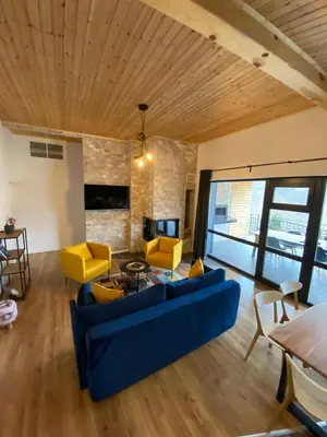 a living room with a blue couch and yellow chairs at Villa Dea & Villa Ina - Villas & SPA Park in Velingrad by Flat Mаnager in Velingrad