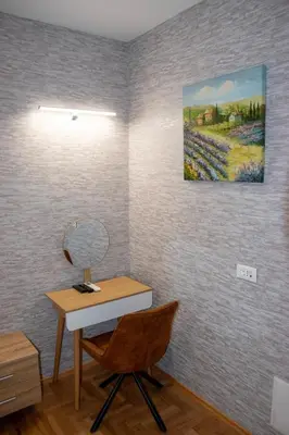 a desk with a chair and a painting on the wall at Roza Home in Sofia