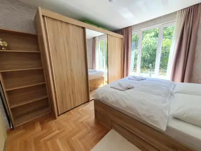 a bedroom with a bed and a large window at Roza Home in Sofia