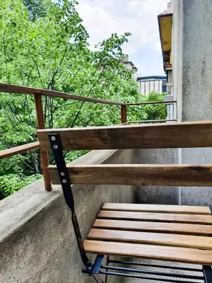 a wooden bench sitting on top of a balcony at Roza Home in Sofia