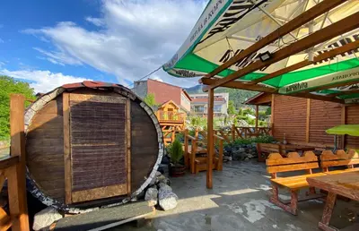 a large wooden barrel sitting on top of a patio at Тихият кът in Sapareva Banya