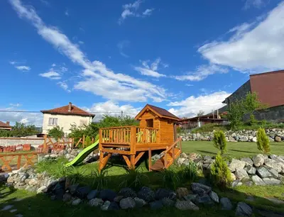 a wooden house with a slide in a yard at Тихият кът in Sapareva Banya