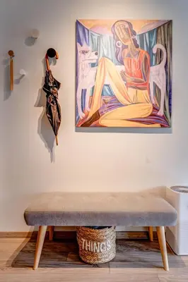 a bench in a room with a painting on the wall at Park Loft next to Eagle's Bridge in Sofia