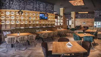 a dining room with wooden tables and chairs at City Park Inn in Plovdiv