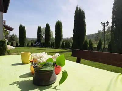 a table with flowers on it with a bench at Къща за гости 
