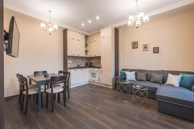 a living room with a couch and a table and a kitchen at Semiramis` Suite 2-bedroom Lux Apartment in Sofia