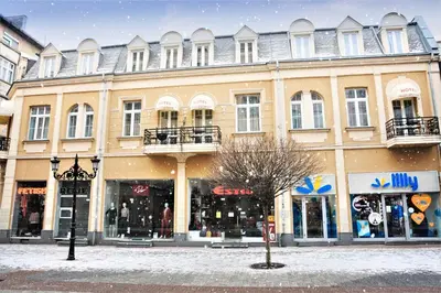 a large building on a city street with stores at Plovdiv City Center Hotel in Plovdiv
