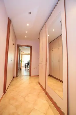 a hallway with white cabinets and a large mirror at Мария Парк in Sandanski