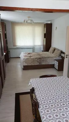 a large bedroom with two beds and a table at Къща за гости - Софи, гр. Девин in Devin