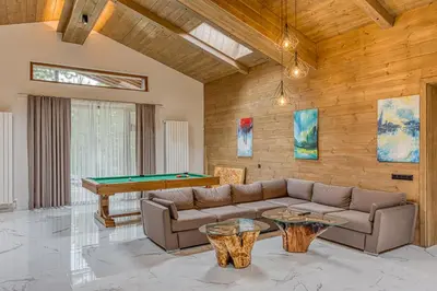 a living room with a couch and a pool table at Pirin Style Villa & Spa in Bansko