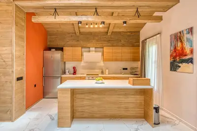 a kitchen with wooden cabinets and a refrigerator at Pirin Style Villa & Spa in Bansko