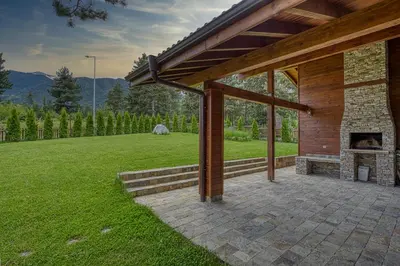 an outdoor patio with a fireplace in a yard at Pirin Style Villa & Spa in Bansko