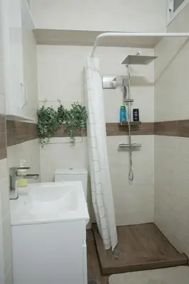 a bathroom with a white sink and a shower at Landmark Apartment in Sofia