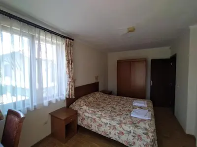 a bedroom with a bed and a large window at Вила Магдалена, к-с Александриа in Dobrinishte