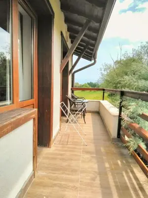 a balcony of a house with a bench on it at Вила Магдалена, к-с Александриа in Dobrinishte