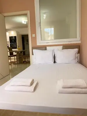 a large white bed with two folded towels on it at Irina Apartment in Sandanski