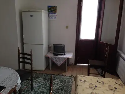 a room with a refrigerator and a table with a tv at Katya Guest House in Smolyan