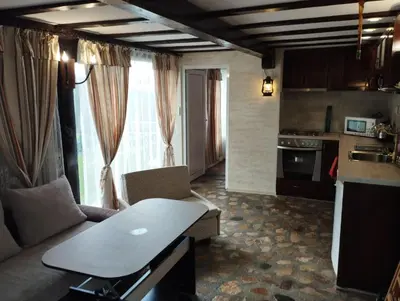 a living room with a couch and a table in a kitchen at Семейна къща Лазарови in Sapareva Banya