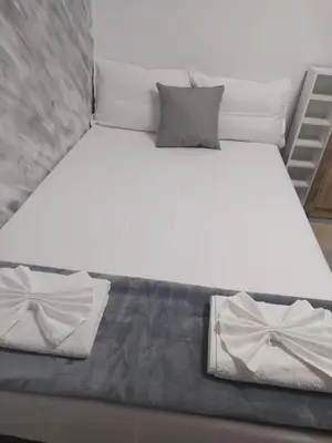 a large white bed with two pillows on it at Каламанди in Asenovgrad