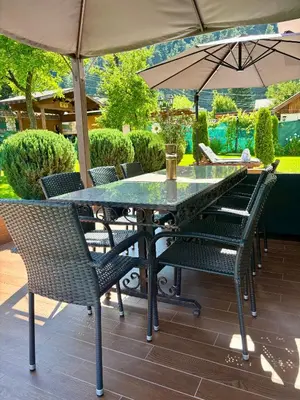 a table and chairs under an umbrella on a patio at Villa Rila Garden in Beli Iskar