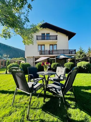 a table and chairs in front of a house at Villa Rila Garden in Beli Iskar