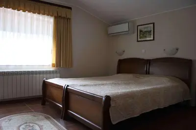 a bedroom with a bed and a window at Spartak Family Hotel in Smolyan