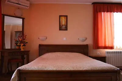 a bedroom with a bed and a mirror at Spartak Family Hotel in Smolyan