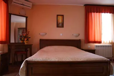 a bedroom with a bed and a large mirror at Spartak Family Hotel in Smolyan
