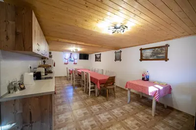 a kitchen and dining room with two tables and chairs at Къща за гости детелина - лина in Sapareva Banya