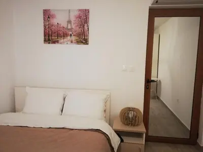 a bedroom with a bed with a picture on the wall at Къща за гости детелина - лина in Sapareva Banya